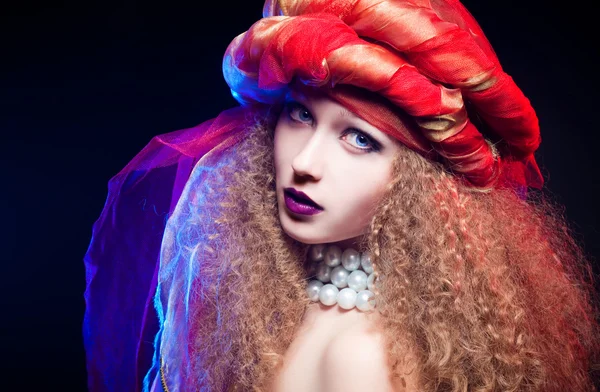 Menina bonita com cabelo encaracolado e um turbante. Retrato criativo — Fotografia de Stock