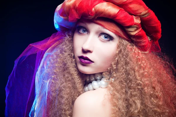 Schönes junges Mädchen mit lockigem Haar und Turban. Kreatives Porträt — Stockfoto
