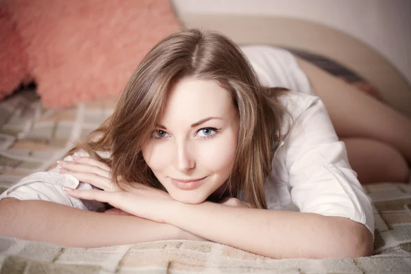 Sexig och vacker flicka i vit skjorta i sängen — Stockfoto