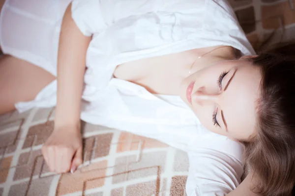 Yataklar Beyaz gömlekli seksi ve güzel bir kız — Stok fotoğraf