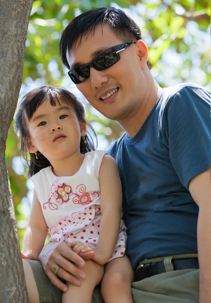 Азіатський батько і дочка сидить на дереві — стокове фото