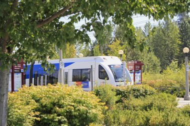 Light rail train seen through landscape clipart