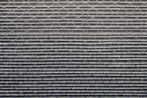 Closeup background of a dirty gray home furnace air filter that was white when it was new.