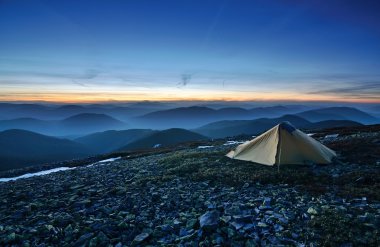 Tourist tent in the rocky mountains and first star clipart