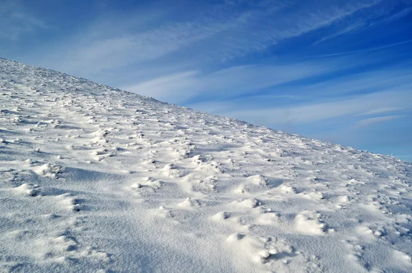 Snowy mountain slope and blue sky — Stock Photo, Image