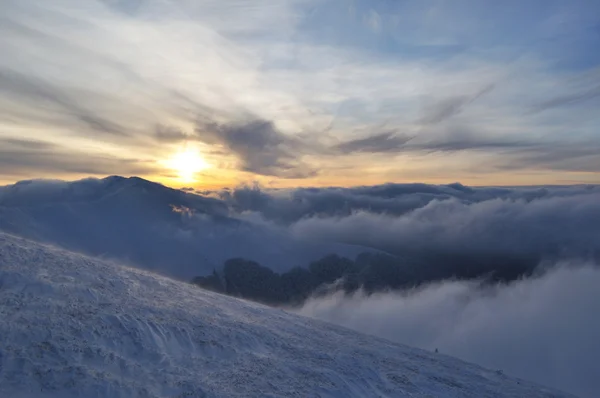 Pôr do sol em montanhas nebulosas de inverno — Fotografia de Stock
