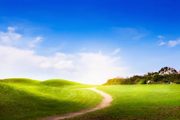 Wiosnę krajobraz z zielonej trawy, drogi i chmury — Zdjęcie stockowe