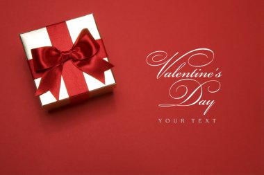Art golden gift box with a red bow on red background