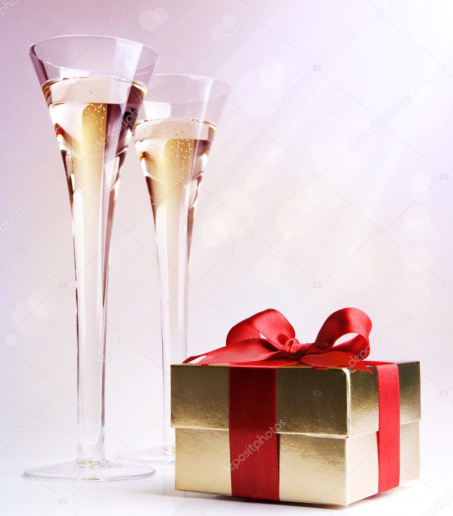 Two glasses of champagne and a gift box