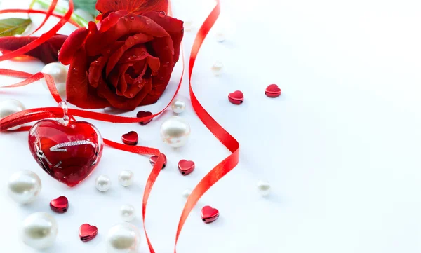 Tarjeta de felicitación de San Valentín con pétalos de rosas rojas y joyas escuchar — Foto de Stock