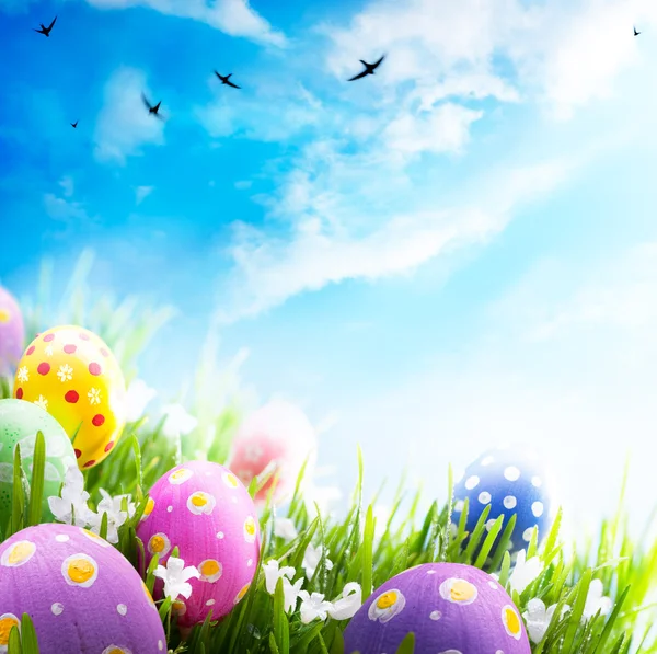 Art Easter eggs decorated with flowers in the grass on blue sky — Stock Photo, Image