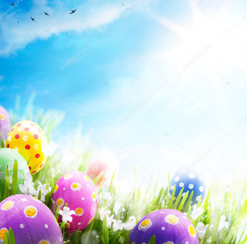 Art Easter eggs decorated with flowers in the grass on blue sky