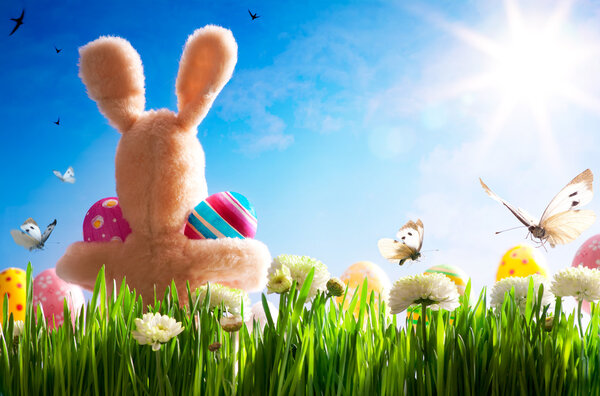 Art Easter teddy bunny and Easter eggs on green grass