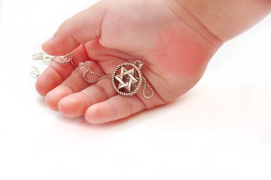 Child's hand holding silver star of David clipart