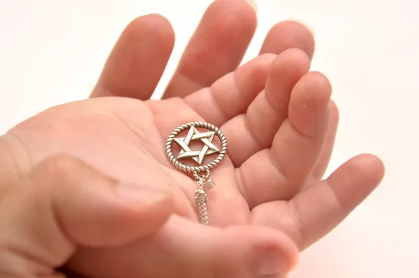 Руки матери и ребенка держат серебряную звезду Давида — стоковое фото
