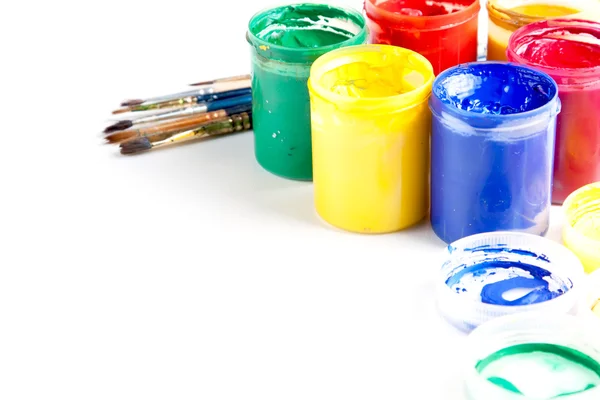 Jars of brightly coloured paint with brushes — Stock Photo, Image