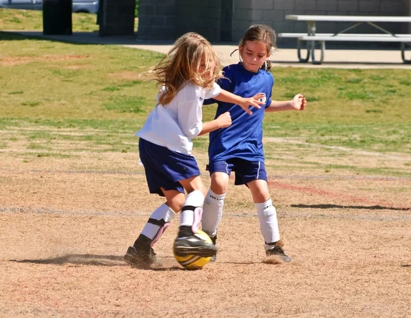 Два молодих дівчат, які ведуть боротьбу за м'яч футбол — стокове фото