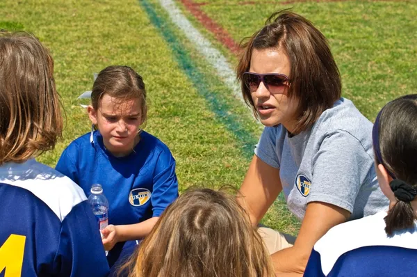 Vrouw Coaching Girl's Soccer Stockfoto