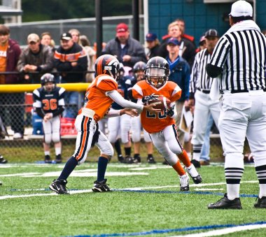 Quarterback Handing off the Football clipart