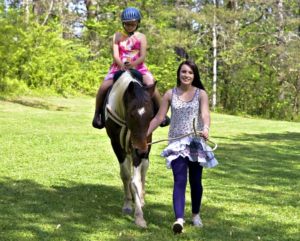 Ребенок учится ездить на лошади — стоковое фото