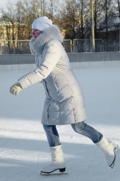 stock image A girl in winter sports clothing on ice skates, ice skating