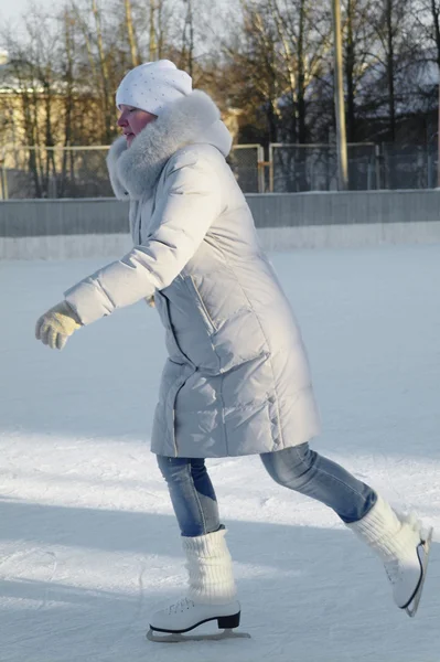Una chica con ropa deportiva de invierno en patines de hielo, patinaje sobre hielo Imágenes de stock libres de derechos