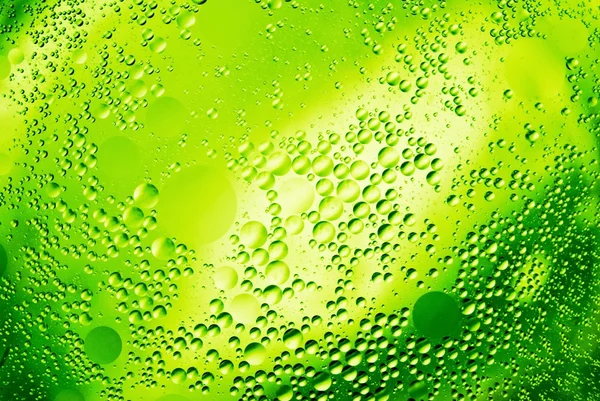 Drops of oil on green water — Stock Photo, Image