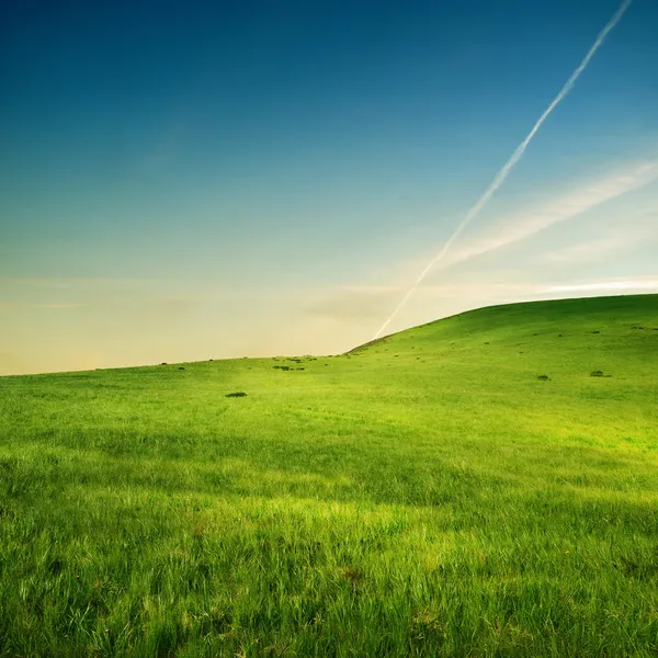 Слід літака над зеленими пагорбами Ліцензійні Стокові Фото