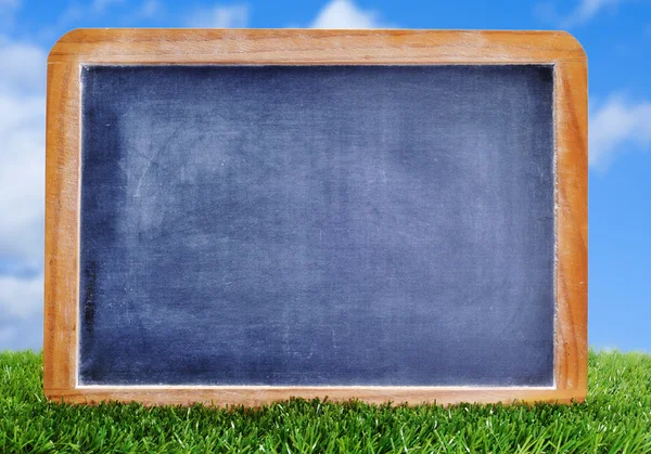 Lege schoolbord op het gras — Stockfoto