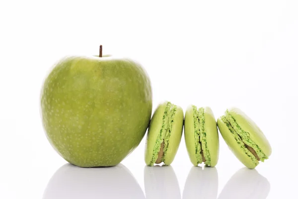 Green apple with macaroons — Stock Photo, Image