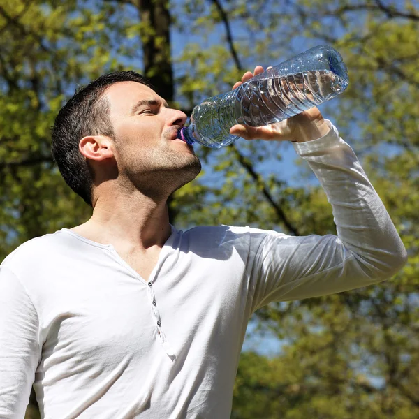 Красивый мужчина пьет воду. — стоковое фото