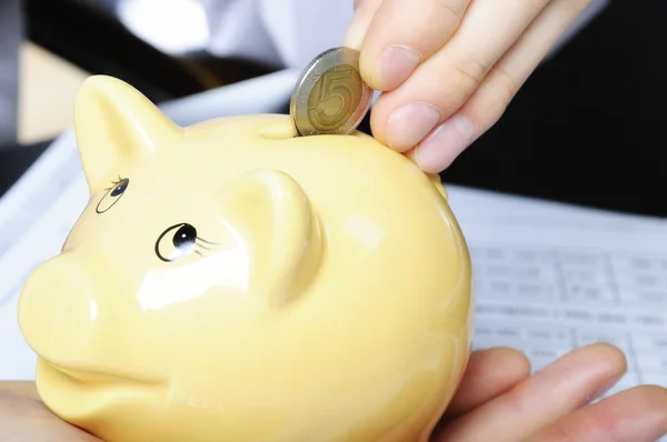 Dropping one coin to piggybank — Stock Photo, Image