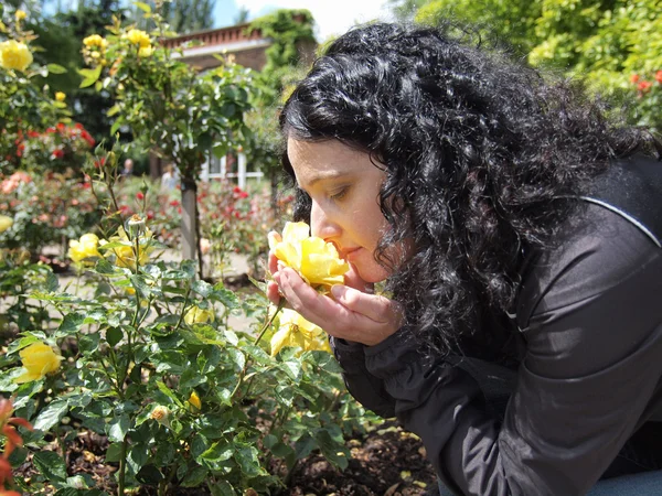 Όμορφη μελαχρινή μυρίζοντας τριαντάφυλλα — Stockfoto