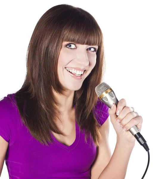 Szczęśliwa młoda kobieta śpiewa z mikrofonem — Zdjęcie stockowe