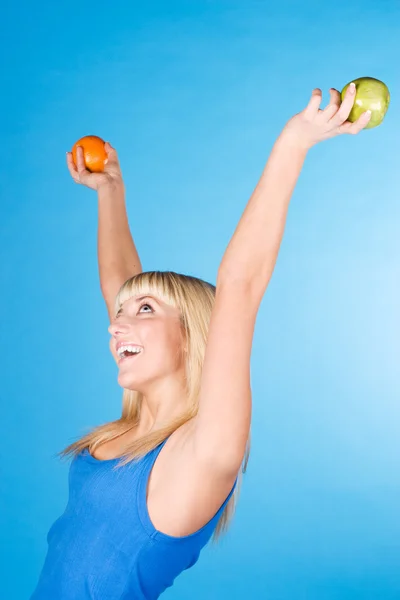 Chica sonriente con una manzana y una naranja — Foto de Stock