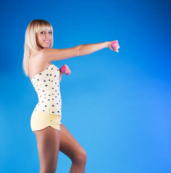 Blondýny fena cvičení s růžové činky — Stock fotografie