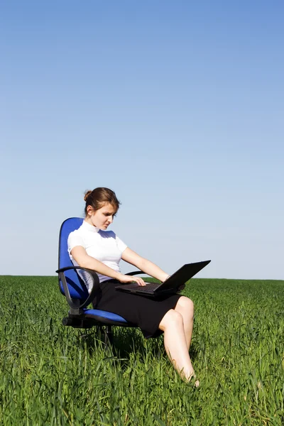 Mujer de negocios seria sentada en el sillón afuera y escribiendo en — Foto de Stock