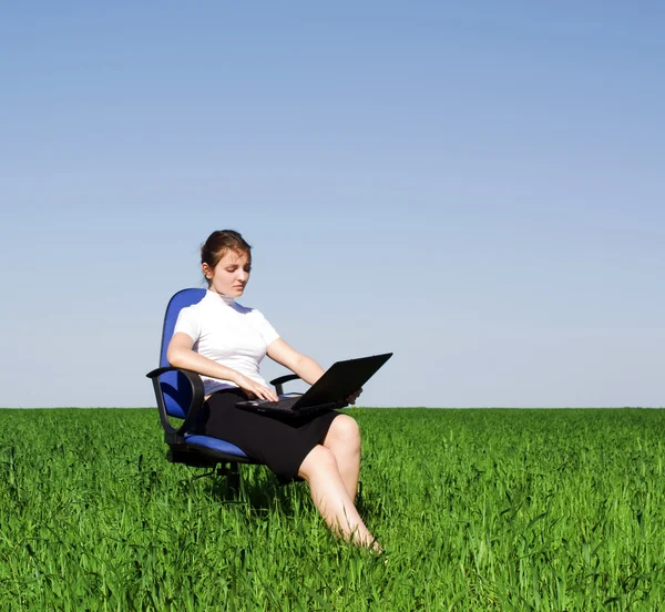 Vertrouwen zakenvrouw zitten in een leunstoel op het veld — Stockfoto
