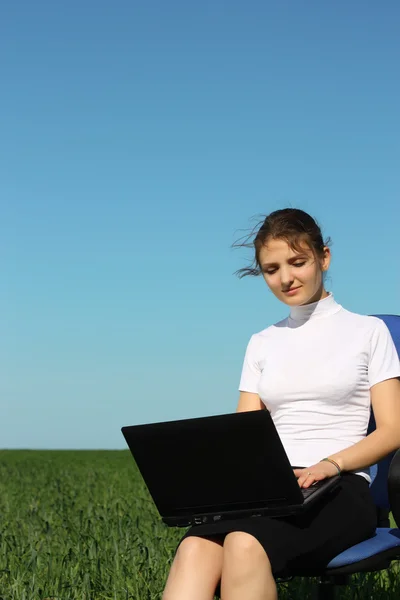 Donna d'affari su un computer portatile in un campo fuori dall'ufficio — Foto Stock