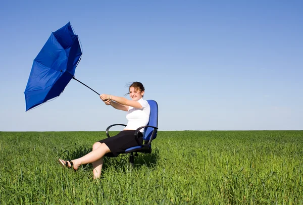 Business women with an umbrella on a grass land — Stock Photo, Image