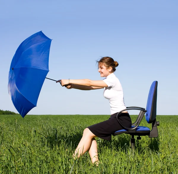 Businesswoman holding umbrella in park — Stock Photo, Image