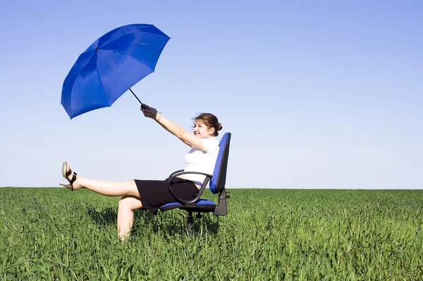 Businesswoman with blue Umbrella on meadow — Stock Photo, Image