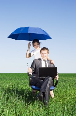 Happy businessmen working on laptop. Outdoors on a sunny day clipart