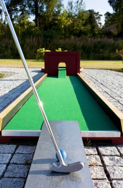 Putting at a mini golf leisure facility. clipart