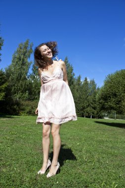 mutlu bir genç güzel kadın mavi gökyüzü altında.