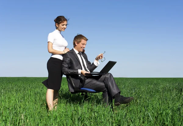 Jovens e confiantes empresários trabalhando no laptop. Um gramado verde, sp — Fotografia de Stock