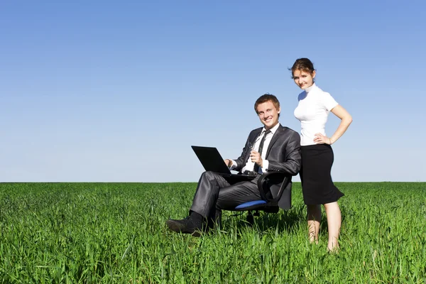 Jovens e confiantes empresários trabalhando no laptop. Um gramado verde, sp — Fotografia de Stock