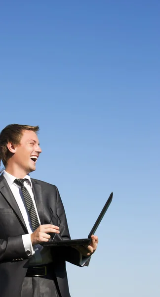 Positieve succesvolle zakenman met een laptop op een zonnige veer — Stockfoto