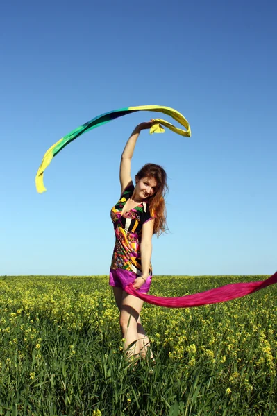 Девушка на желтом поле с шарфом — стоковое фото