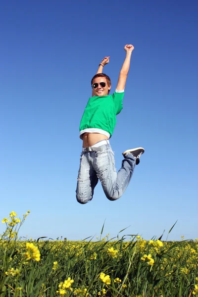 Joven saltando en un campo amarillo en el verano —  Fotos de Stock
